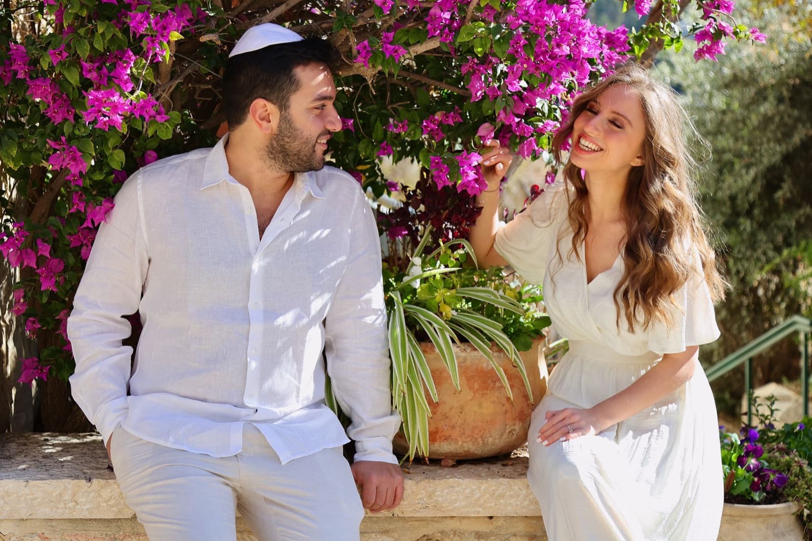 Couple photographié lors d’un shooting save the date, sous les bougainvilliers